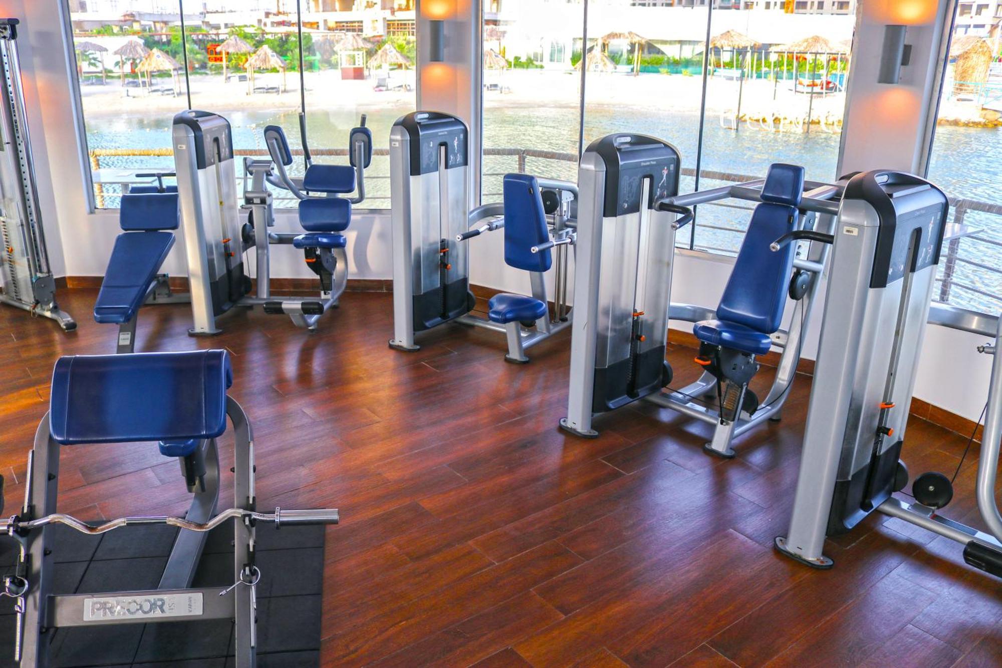 Lagoona Beach Luxury Resort And Spa Манама Екстериор снимка The photo shows a gym or fitness center with several pieces of exercise equipment. There are multiple machines designed for strength training, including seated machines with padded seats and backrests. The equipment appears to have a modern design an